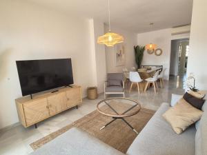 a living room with a large flat screen tv at Apartamento en primera línea de playa, Mi Capricho in Sitio de Calahonda