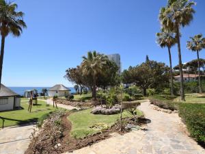 a park with palm trees and a playground at Apartamento en primera línea de playa, Mi Capricho in Sitio de Calahonda