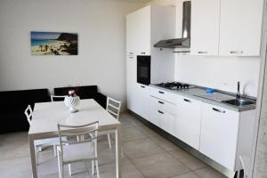 Una cocina con gabinetes blancos y una mesa y sillas blancas. en Villa Luxury fronte mare, en San Vito lo Capo 18 fotos más