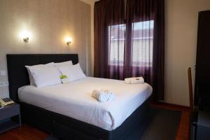 Postel nebo postele na pokoji v ubytování Hotel Le Divona "au coeur de Divonne"