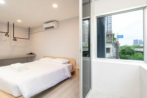 a bedroom with a bed and a large window at Wash House Chatuchak in Bangkok