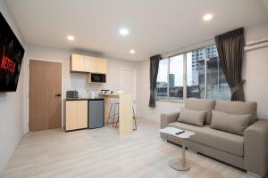 a living room with a couch and a kitchen at Wash House Chatuchak in Bangkok