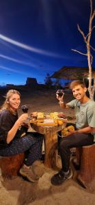 a man and woman sitting at a table with glasses of wine at Mana Star Lounge Hotel in Villavieja