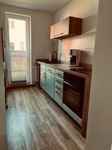 eine Küche mit Herd und Mikrowelle in der Unterkunft Ferienwohnung Schmalkalden in Schmalkalden