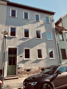 ein Gebäude mit einem davor geparkten Auto in der Unterkunft Ferienwohnung Schmalkalden in Schmalkalden