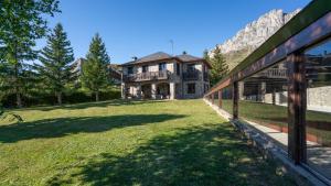 una casa grande con un patio grande con una cerca en Casa Martica, en Formigal