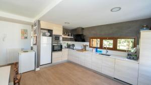 cocina grande con electrodomésticos blancos y suelo de madera en Casa Martica, en Formigal