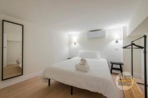 a white bedroom with a large bed and a mirror at Nuevo y Céntrico Apt 7px en plena Plaza del Carmen E2 in Madrid
