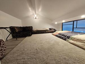 a bedroom with a bed and a couch and a window at Disney 1 in Mouroux