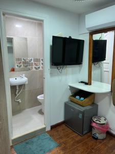 a bathroom with a toilet and a television on the wall at Rooftop Rooms in Male City