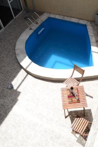 a bench and a chair next to a swimming pool at Casa amplia con garaje, pileta y aire acondicionado en todas las habitaciones en zona residencial de Mendoza in La Cieneguita