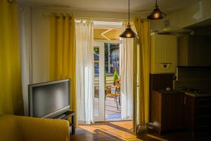 a living room with a tv and a sliding glass door at ARTHUR Apartment in Sinaia