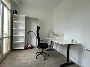 ein Büro mit einem Schreibtisch und einem Stuhl in einem Raum in der Unterkunft Appartement T4 Centre Ville C2 in Châteauroux
