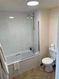 Un baño con bañera, inodoro y ducha. en Wick Bay Apartments, en Wick 10 fotos más