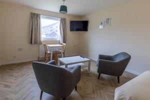 una habitación de hotel con 2 sillas y una mesa en Wick Bay Apartments, en Wick