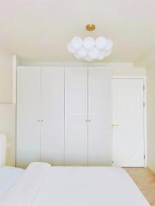 a bedroom with white cabinets and a white bed at Flaneur Shanghai Hongqiao B&B Near National Exhibition and Convention Center in Shanghai