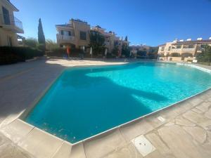 a large blue swimming pool in front of some buildings at William and Emily Apartment in Polis Chrysochous