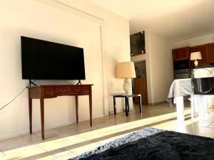 a living room with a flat screen tv on a wall at Ferme de Grandchamp in Boudry