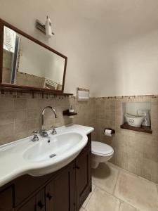 a bathroom with a sink and a toilet and a mirror at Luxury Trulli Sabotino 48 in Alberobello