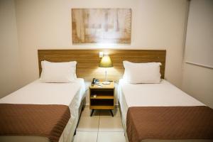 Una habitación de hotel con dos camas y una mesita de noche. en Ville Hotel Gramadão, en Votuporanga 57 fotos más