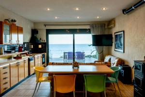 cocina con mesa y sillas y vistas al océano en Deck House, en Pefkali