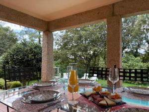 un tavolo di vetro con un piatto di cibo sopra di Sobreiros House - Gerês a Terras de Bouro