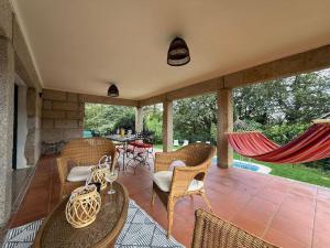 un patio con sedie, tavoli e amaca di Sobreiros House - Gerês a Terras de Bouro