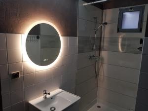 a bathroom with a sink and a mirror at Les Souchottes, charmante maisonnette in Bulligny