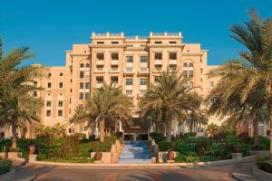 a large building with palm trees in front of it at The Westin Dubai Mina Seyahi Beach Resort and Waterpark in Dubai