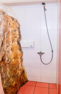 y baño con ducha y pared de roca. en Deck House, en Pefkali 11 fotos más