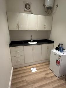 a kitchen with a sink and a white refrigerator at Alhayat Star serviced apartments in Wadi Al Dawasir
