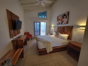 a bedroom with a bed and a television in it at Merrils Deluxe at Veraclub in Negril