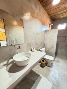 a bathroom with a bowl sink and a toilet at Casa deck Caraíva in Caraíva