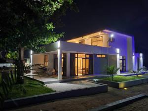 a large white house at night with lights at Bougainvillea Beach Villa in Mponda