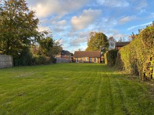 a large yard with a house in the background at Charming 2BR Cottage - Fully Furnished - 10min LGW - Free Parking in Crawley