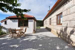 a patio with a table and chairs next to a building at Feel Discovery Maçã Douro in Armamar