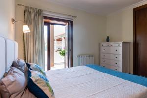 a bedroom with a bed and a window and a dresser at Feel Discovery Maçã Douro in Armamar +18 photos