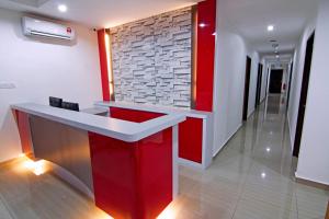 a red and white counter in a room with a brick wall at Thanks Hotel in Parit Buntar