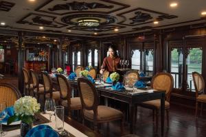 una mujer parada en una mesa en un restaurante en Renea Boutique Cruise, en Ha Long