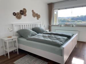 a bedroom with a bed with a window at Gemütliche Gästewohnung, zentral, mit Blick in die Natur in Ennepetal