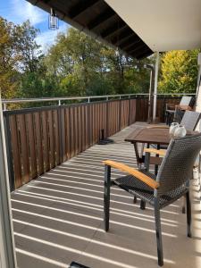 a patio with a table and chairs on a deck at Gemütliche Gästewohnung, zentral, mit Blick in die Natur in Ennepetal