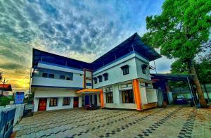 a large white house with a blue roof at kollam Beach Resort in Kollam