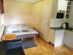 a small room with a bed and a kitchen at Līdumnieki in Vērgale