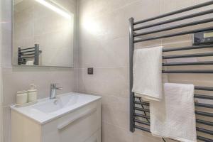 un bagno con lavandino, specchio e asciugamani di La suite Guillaume, T2 cosy contemporain a Vienne Altre 11 foto