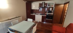una pequeña cocina con una mesa blanca y una silla roja en CA' Botteri, en Venecia