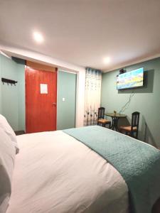 a bedroom with a bed and a flat screen tv at Catag Wasi Casa hospedaje in Cajamarca +3 photos