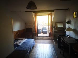 a bedroom with a bed and a desk and a window at Chambres avec salle de bains et cuisine en centre ville Argenton sur Creuse in Argenton-sur-Creuse