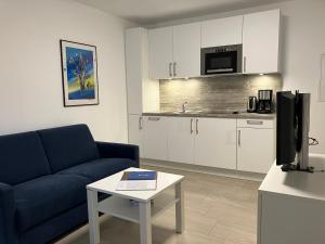 ein Wohnzimmer mit einer blauen Couch und einem Tisch in der Unterkunft Haus Etzold in Norderney