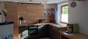 a kitchen with a stove top oven next to a window at Guggenthaler Gipfelblick in Guggenthal +46 photos