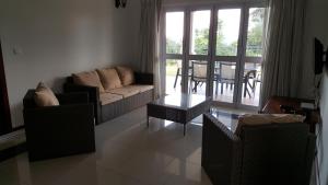 a living room with a couch and chairs and a table at Bambous River Lodge in Bel Ombre